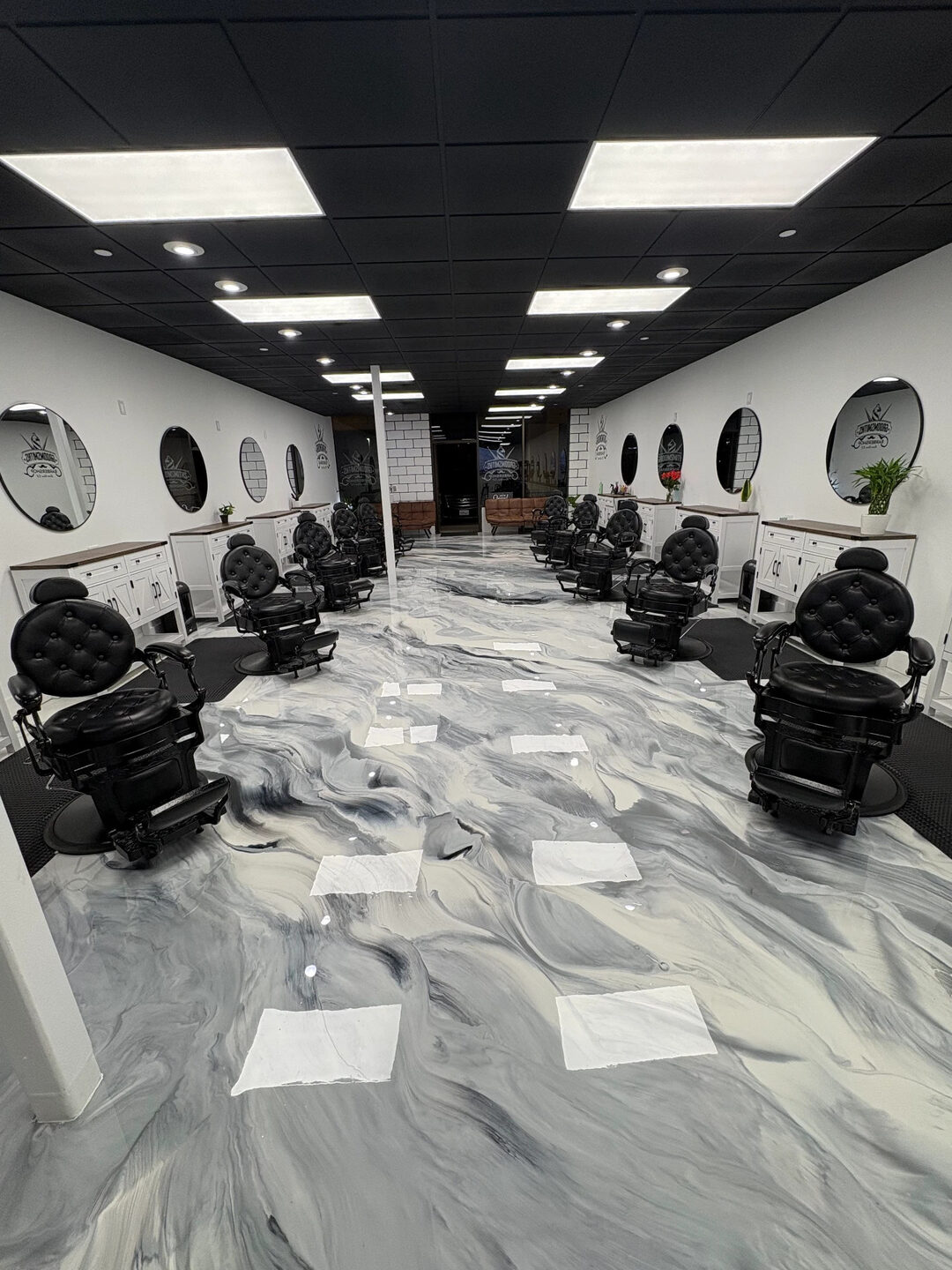 Interior of Groomsmiths Barbershop — rows of barber chairs, round mirrors, and the waiting area